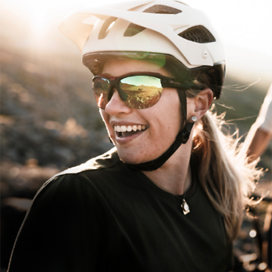 Evil Eye: lachende Frau trägt Sportbrille und Helm